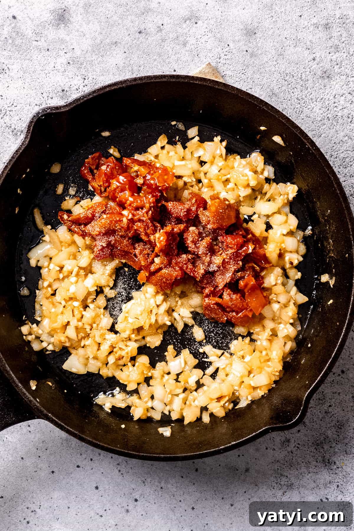 Tuscan Chicken Orzo with Sun-Dried Tomatoes and Spinach 5 Sautéed onions and garlic in a skillet.