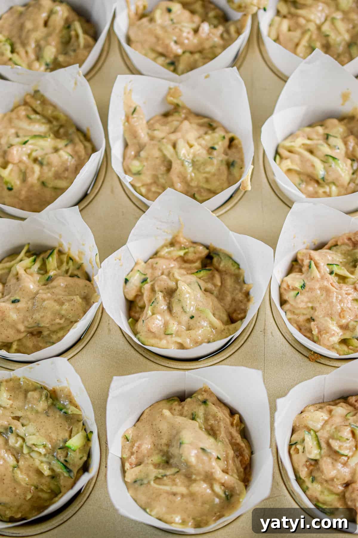 Sourdough Discard Zucchini Muffins Recipe (Quick & Moist) 9 The muffins are in muffin liners in a muffin tin.