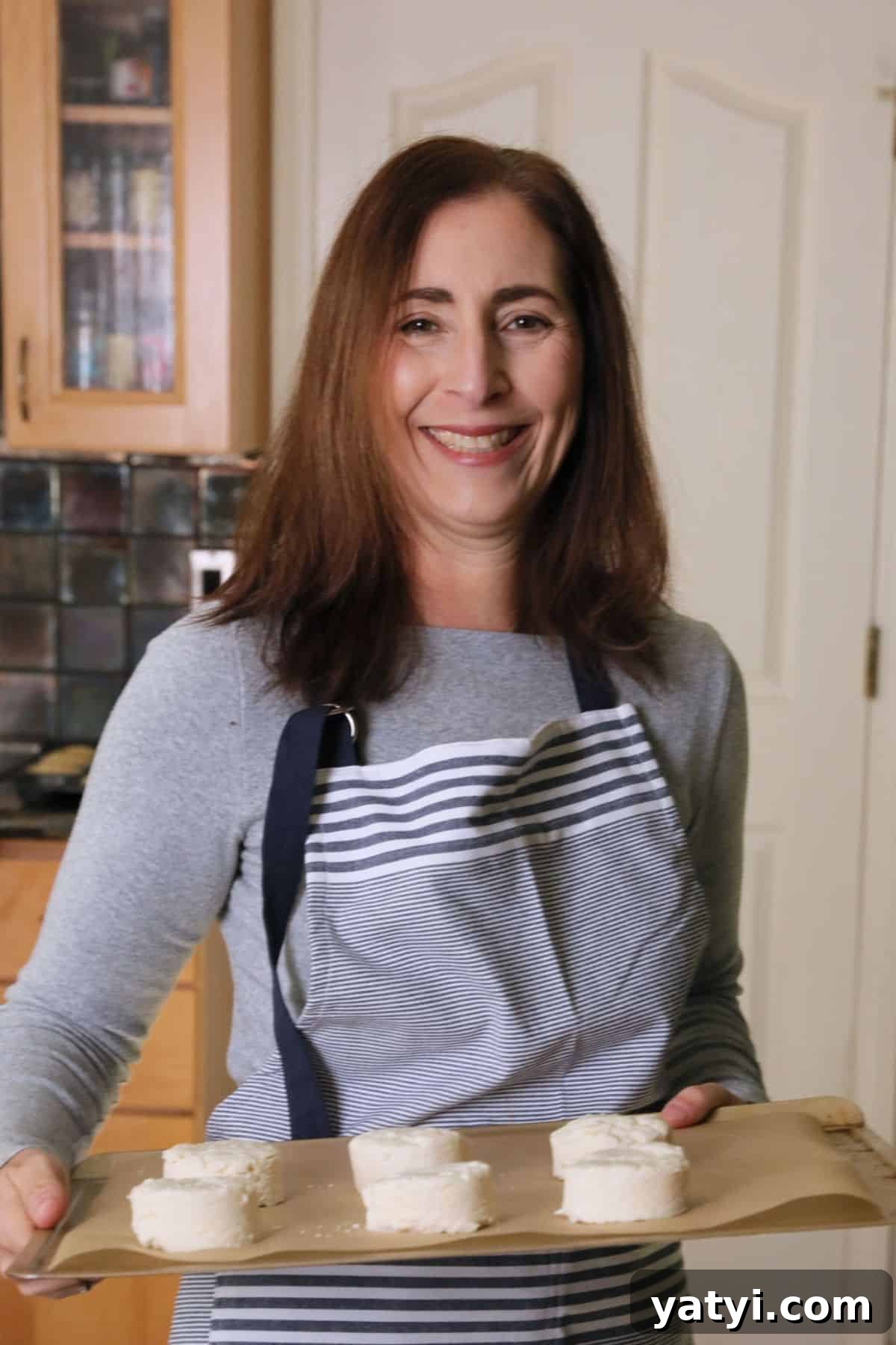 Foil-Packet Grilled Coho Salmon with Lemon and Herbs 3 Sandi holding a tray of biscuits that are going in the oven to bake.