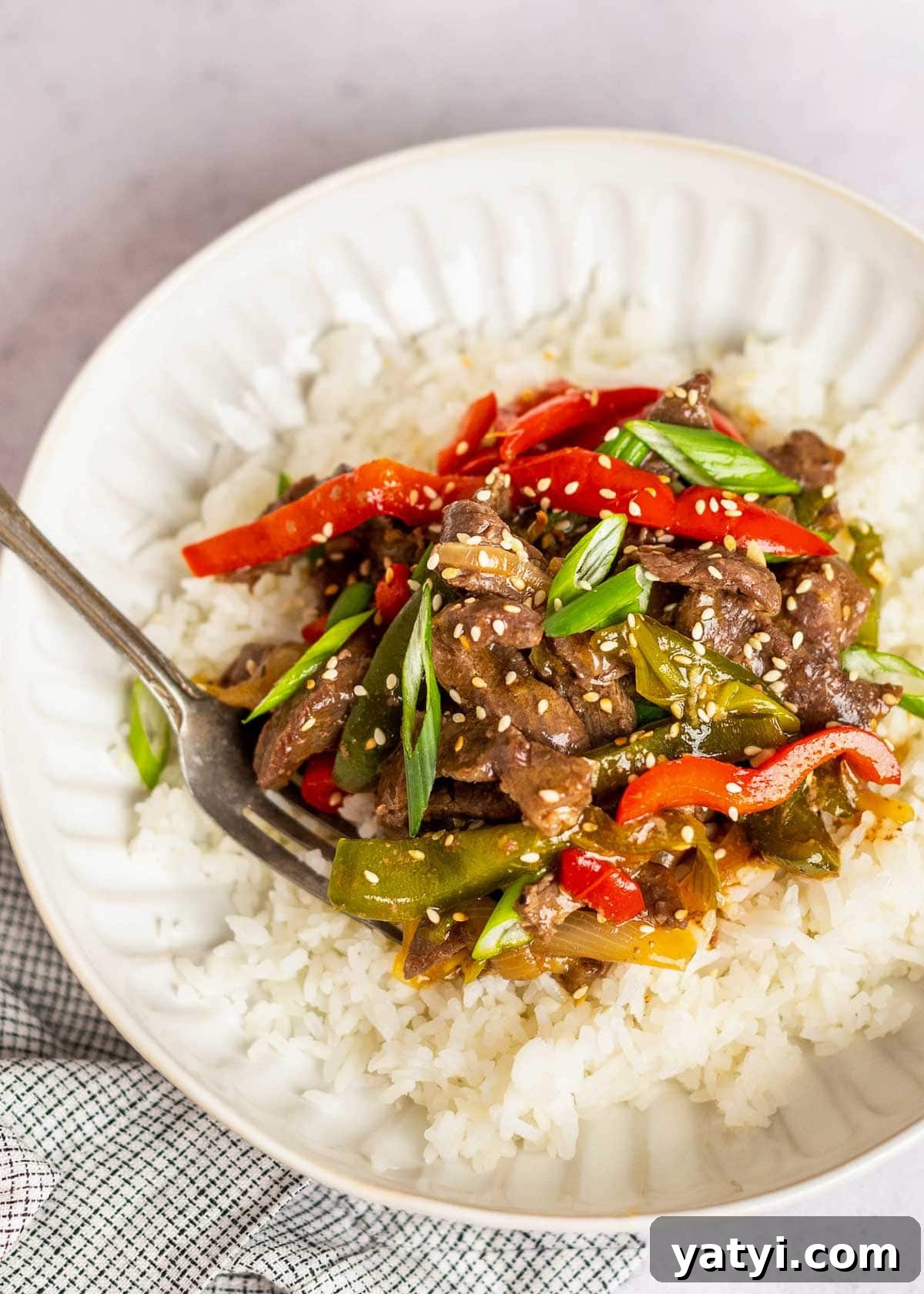 Instant Pot Pepper Steak Recipe: Tender Beef with Bell Peppers 10 pepper steak on plate with rice and fork.