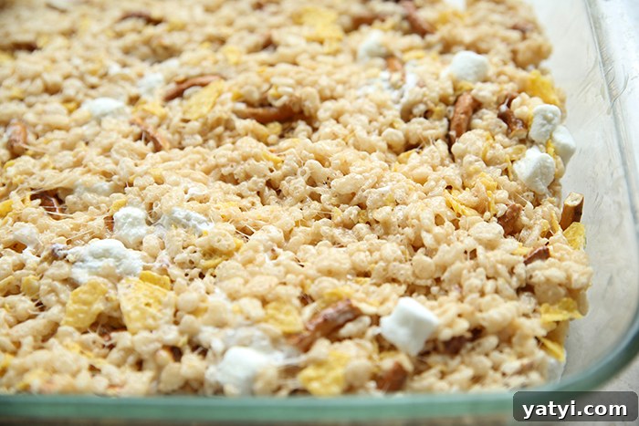 A partial horizontal 9x13 glass baking dish of sweet and salty rice Krispy treats.