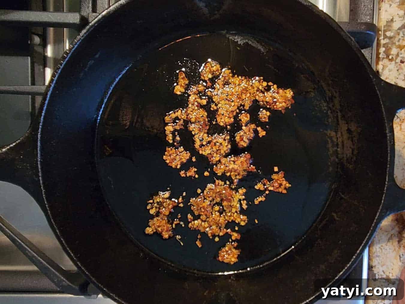 Chili crisp added to a hot skillet.