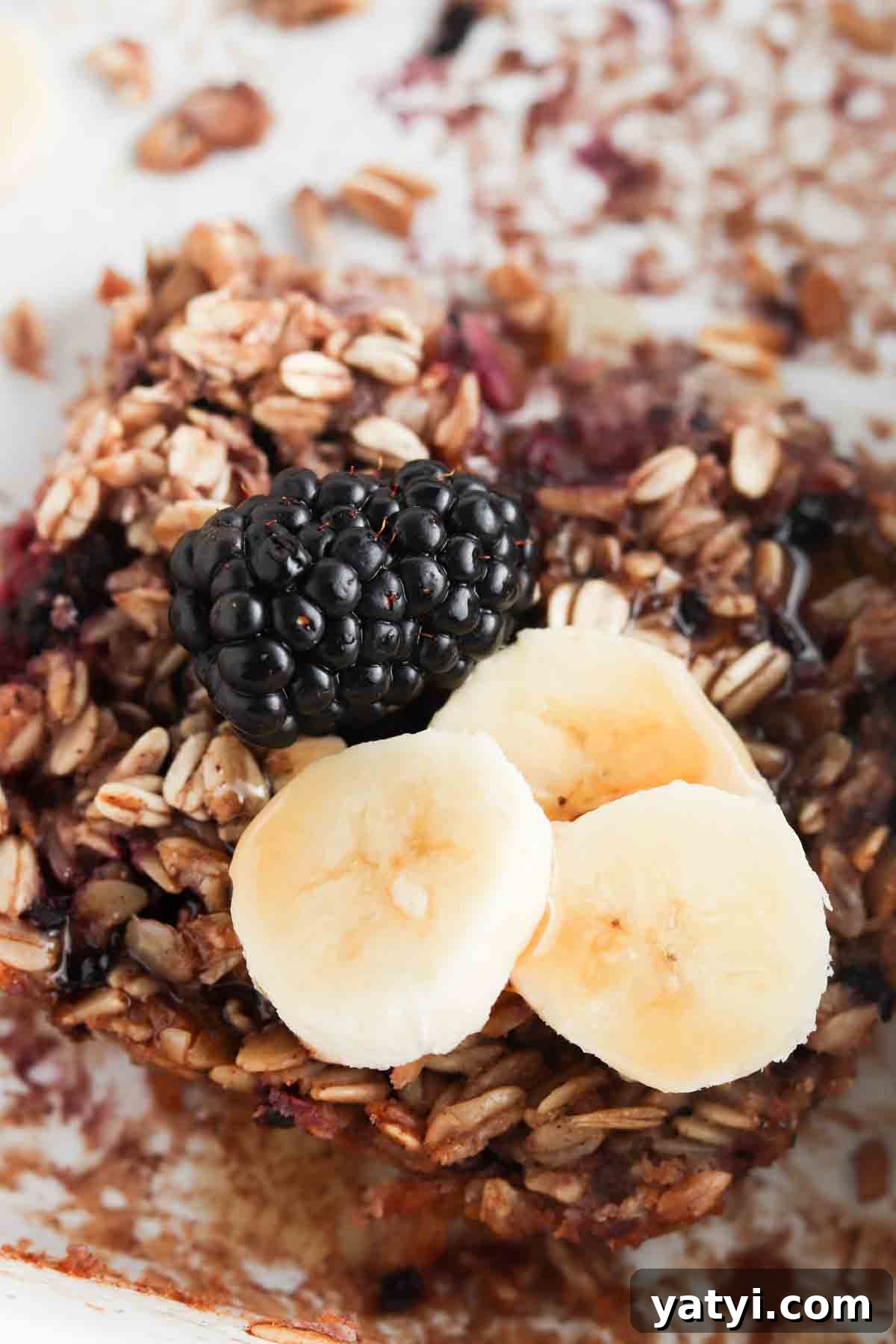 Blackberry Baked Oatmeal Recipe for Summer Brunch 7 Oatmeal bake in a white casserole dish with blackberries and bananas on top.