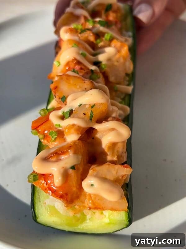A halved zucchini filled with diced vegetables, topped with a creamy sauce and chopped herbs.