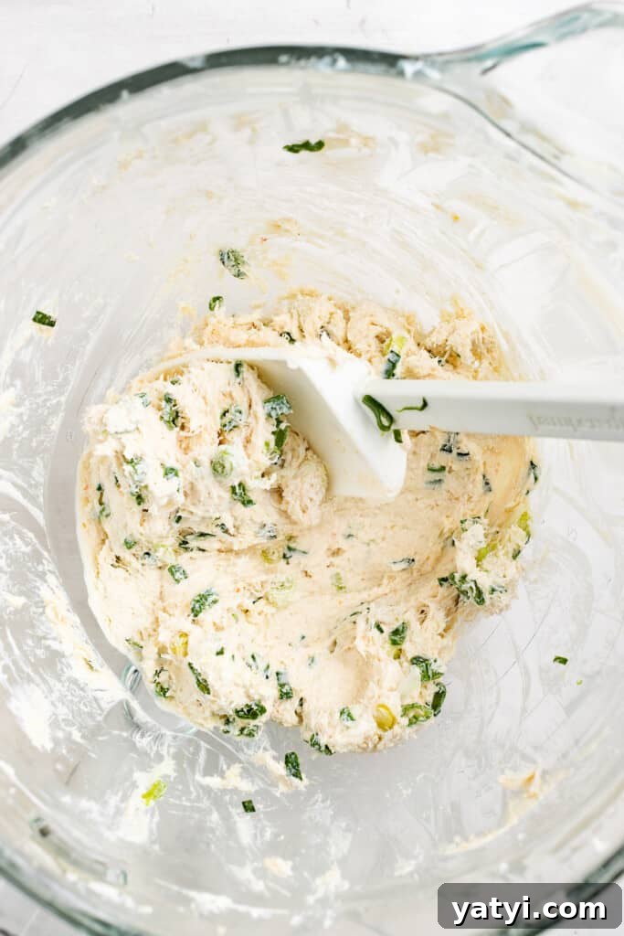 Make the filling. Mixing crab rangoon filling.