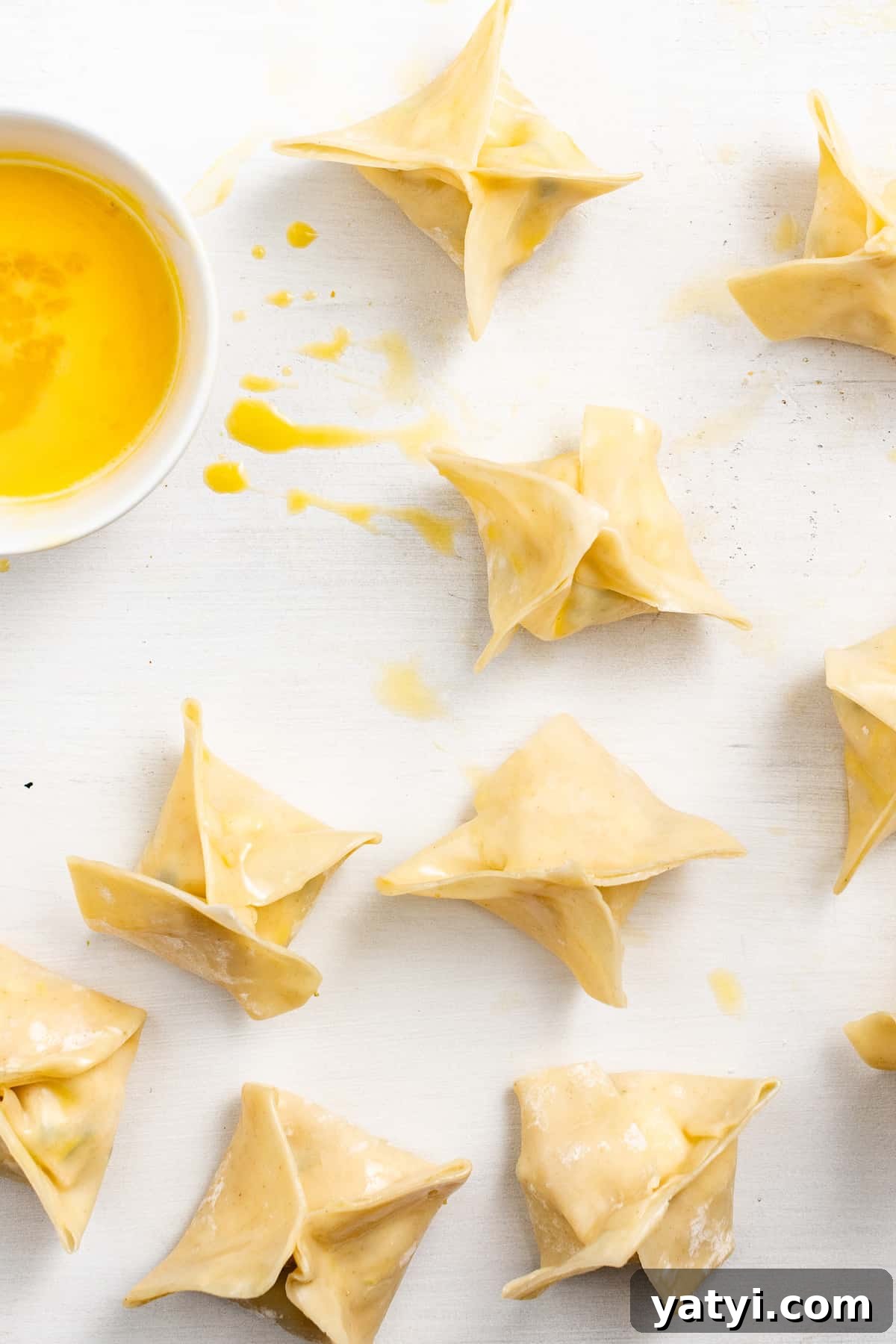 Crispy Air Fryer Crab Rangoon: Quick Seafood Appetizer Recipe 2 Sealing crab rangoon with egg wash.