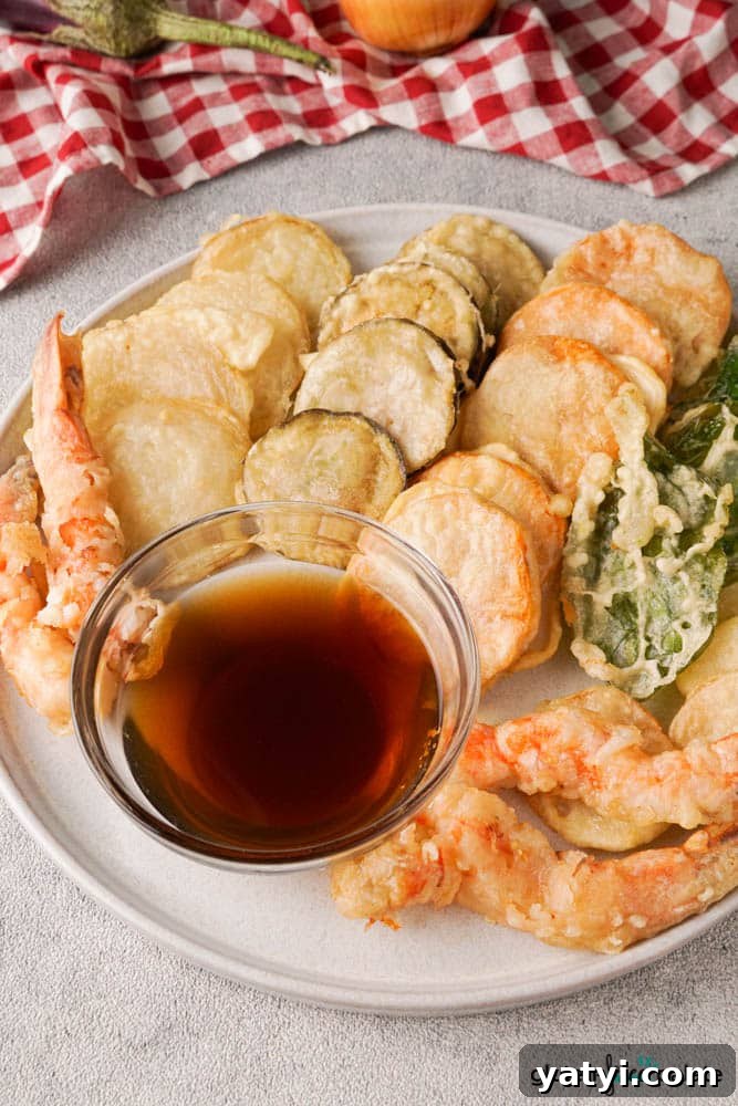 Crispy Gluten-Free Tempura Recipe: Light, Crunchy & Vegan-Friendly 4 Gluten-free tempura on a white serving plate with a dipping sauce.