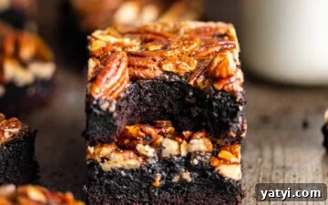 Decadent Pecan Pie Brownies Recipe — Gooey Chocolate Pecan Bars 9 Pecan Pie Brownies stacked on top of each other with a bite missing