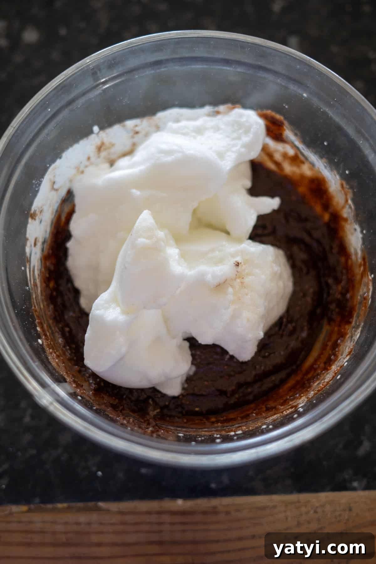 Keto Chocolate Pecan Torte Recipe – Low-Carb Dessert Delight 9 A glass bowl holds a luscious mixture of chocolate batter, whipped cream, and a hint of pecan torte essence, ready to be blended.