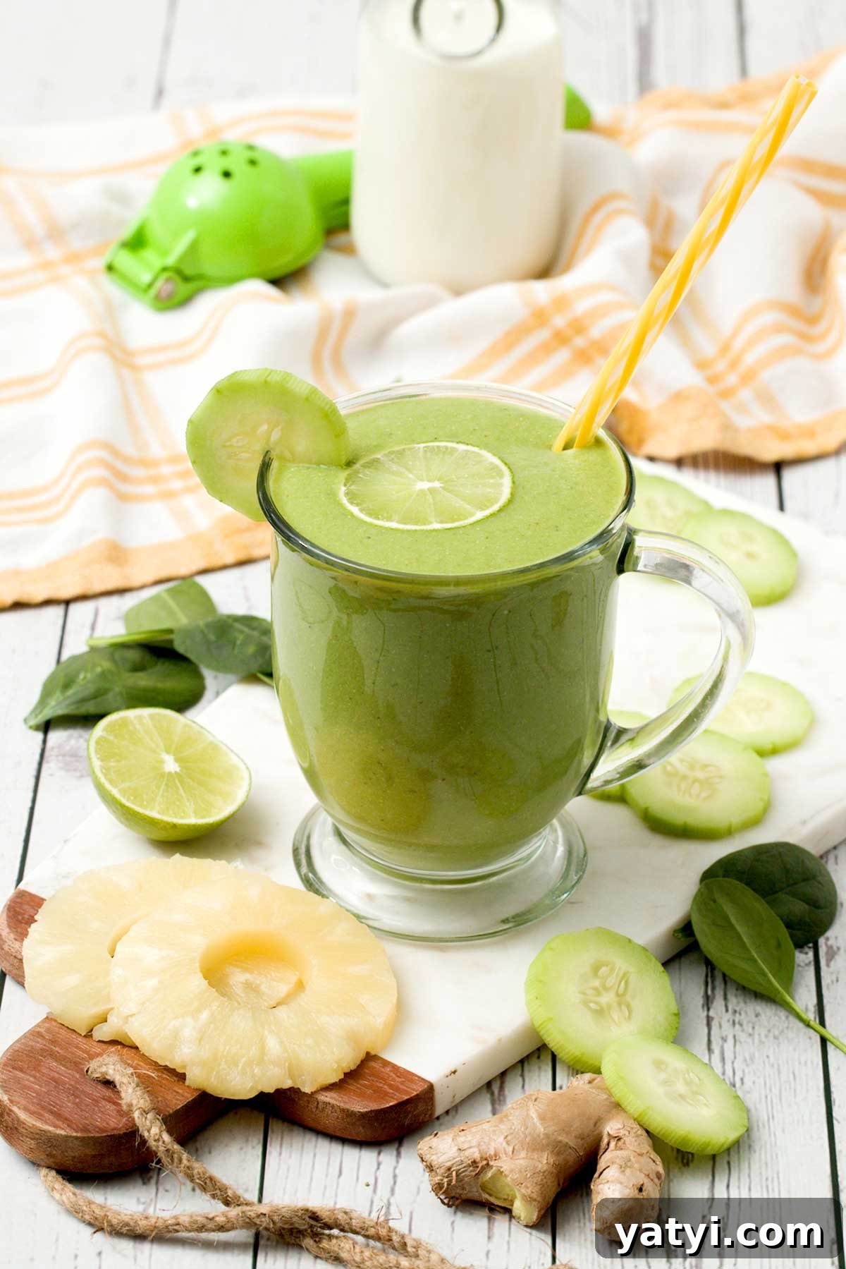 Pineapple, Cucumber & Ginger Detox Smoothie Recipe 3 A detox smoothie with cucumber pineapple ginger and lime with a yellow straw in a glass.
