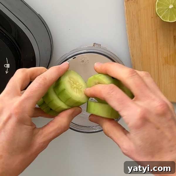 Pineapple, Cucumber & Ginger Detox Smoothie Recipe 5 Adding sliced cucumbers to the smoothie cup.