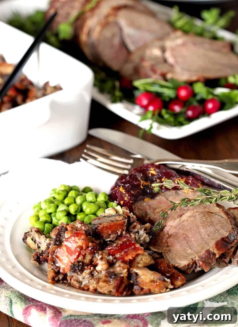 Bourbon-Infused Pumpernickel & Rye Stuffing Recipe 2 Rye and Pumpernickel Dressing with Bourbon on a Plate with lamb, peas, and cranberry sauce.