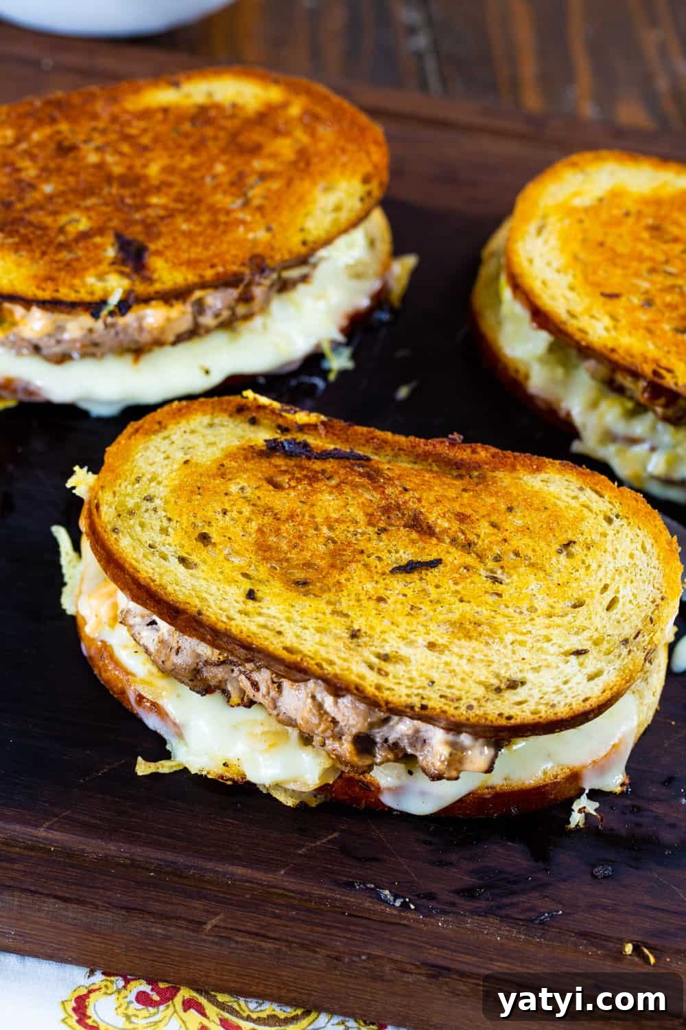 Turkey Reuben Patty Melt Recipe — Tangy Thousand Island Turkey Burgers 3 Three Patty Meltes on a cutting board.