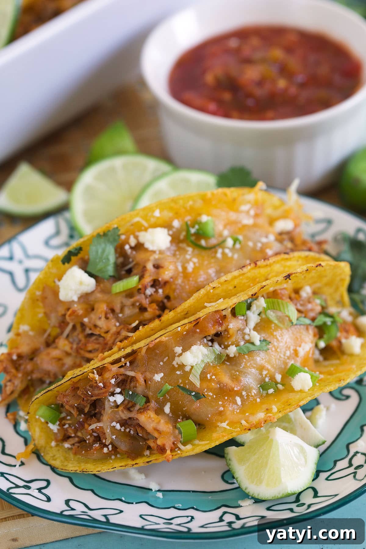 Oven-Baked Chicken Tacos with Crispy Seasoned Filling 6 Two tacos are placed on a blue and white plate.