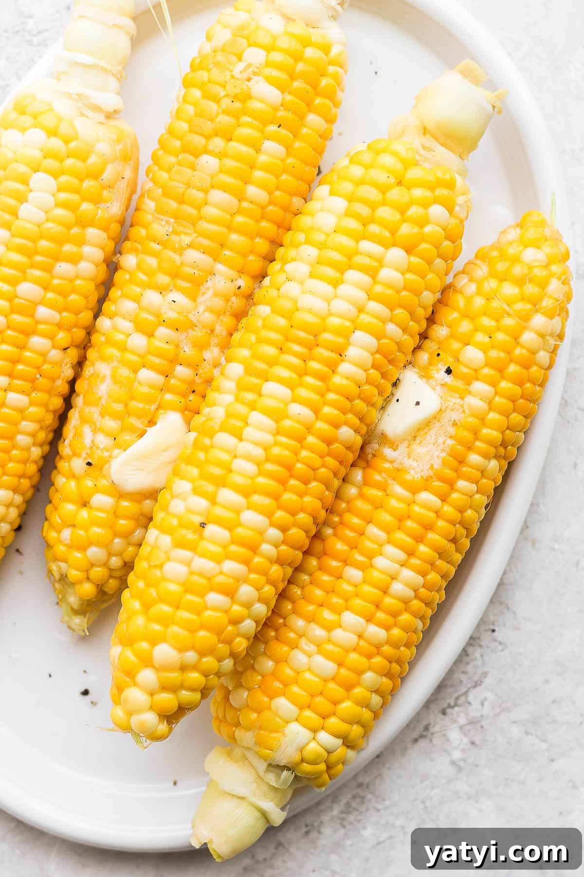 Ultimate Smoked Corn on the Cob Recipe for Sweet, Smoky Flavor 2 Plate of smoked corn on the cob with butter and salt on top.