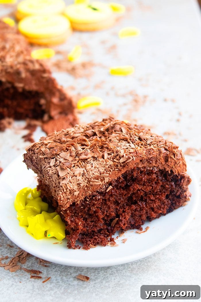 Slice of Chocolate Cake With Chocolate Frosting and Chocolate Shavings on White Plate