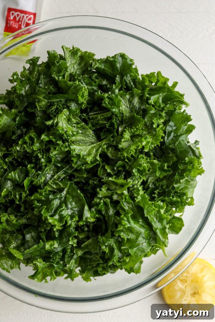 Curried Cauliflower and Kale Salad with Lemon-Tahini Dressing 4 Massaged kale in large mixing bowl with lemon on side by Flora & Vino