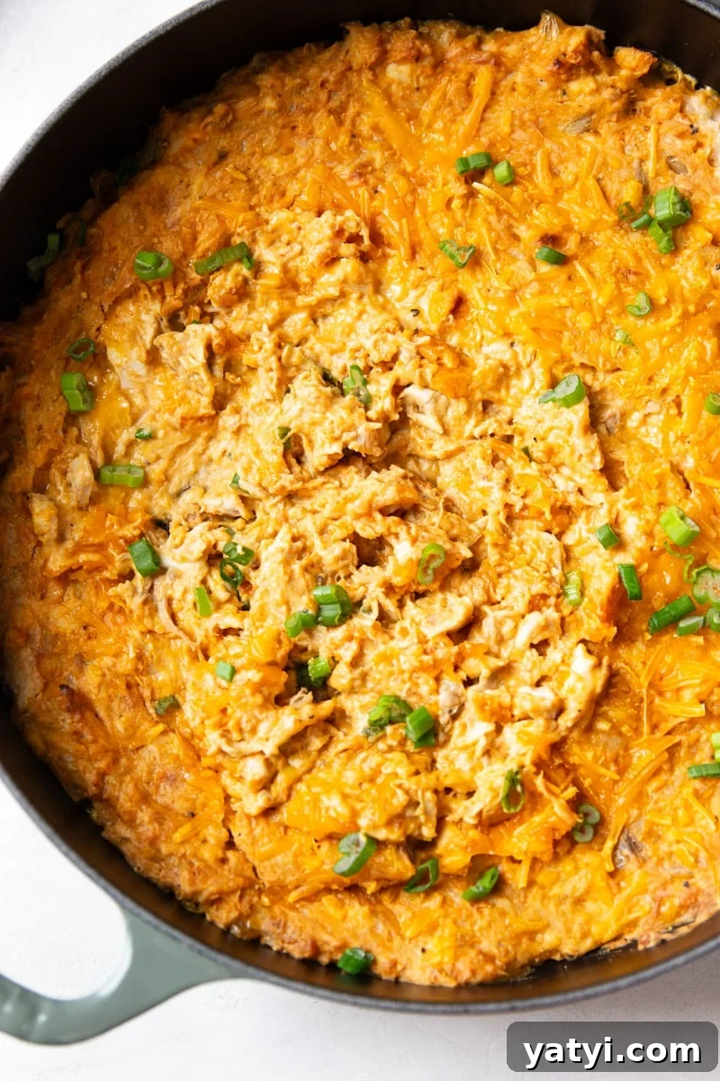 Creamy Buffalo Chicken Dip Recipe for Game Day or Parties 2 Baked buffalo chicken dip with green onions in a skillet.