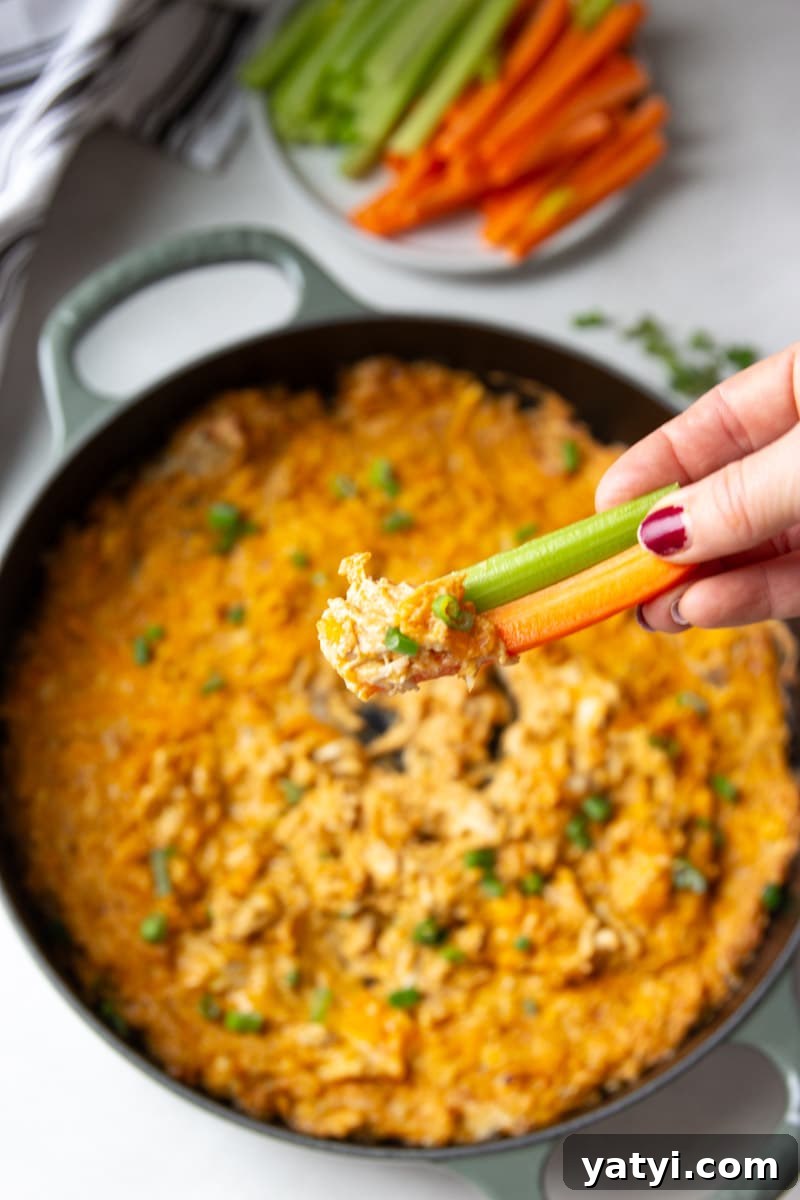 Creamy Buffalo Chicken Dip Recipe for Game Day or Parties 10 Carrots, celery, buffalo chicken dip on a piece of celery and a carrot.