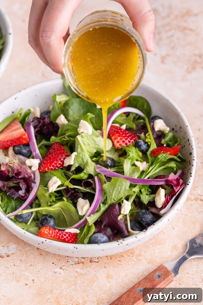 Maple Dijon Vinaigrette with 4 Simple Ingredients 6 Pouring Maple Dijon Vinaigrette over colorful salad