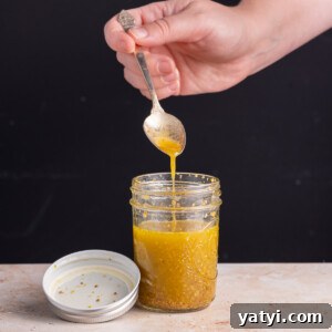Maple Dijon Vinaigrette running off a spoon into a jar
