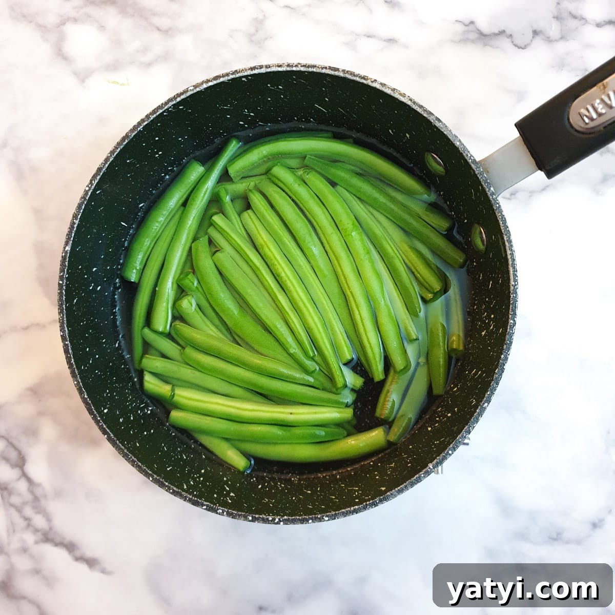 Green beans in a saucepan of water.