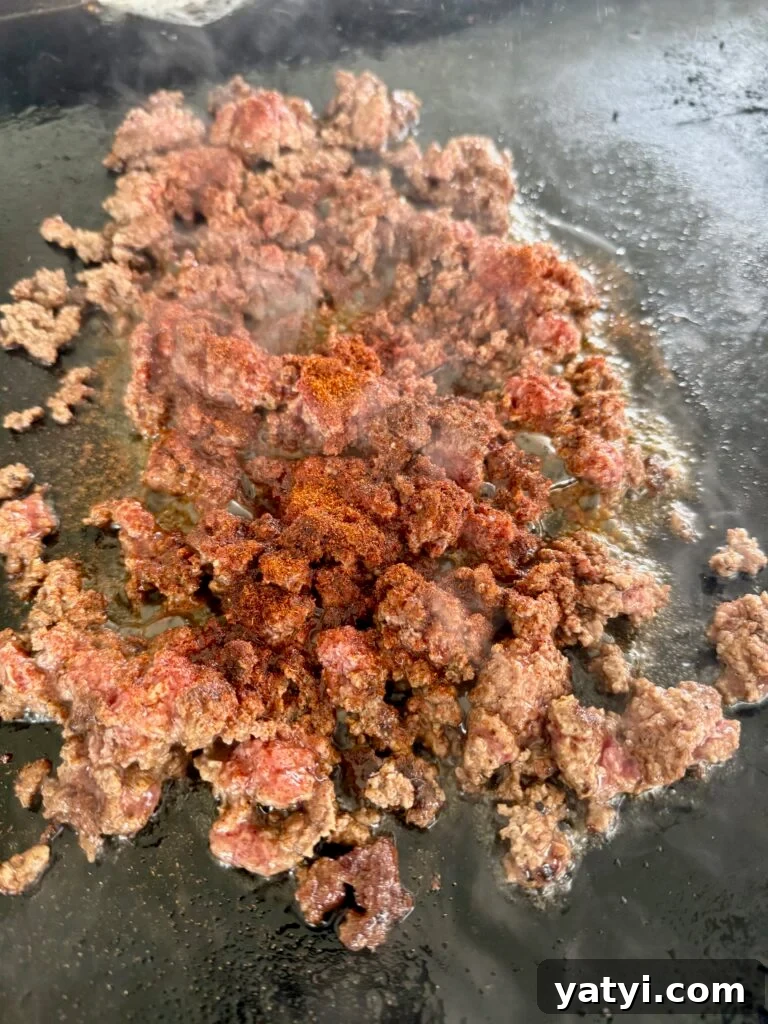 Loaded Taco Tater Tots Made in a Blackstone Pizza Oven 4 ground beef cooking on the griddle