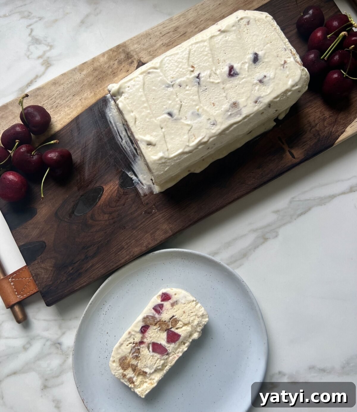 Semifreddo with Crushed Biscotti and Cherry Swirl 6 a slice of semifreddo on a plate next to a loaf on a cutting board