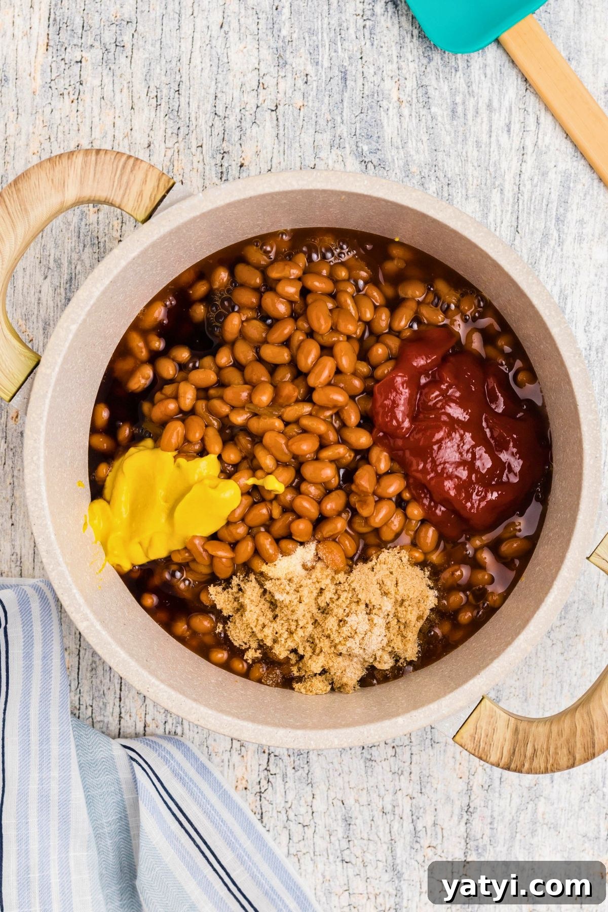 Classic Beanie Weenies Recipe: Hearty Sausage and Beans Meal 5 Mustard, ketchup and other ingredients being added to saucepan.