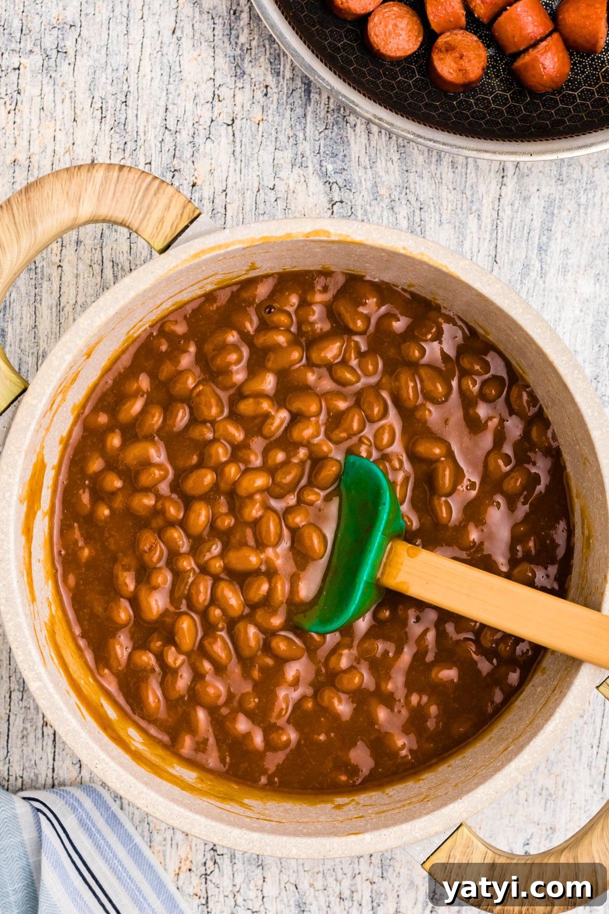 Classic Beanie Weenies Recipe: Hearty Sausage and Beans Meal 6 Beans and other ingredients in saucepan after simmering.