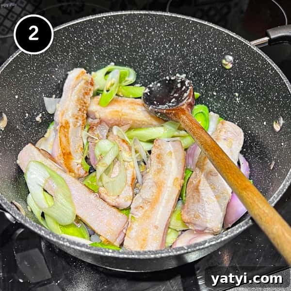 Kimchi Pork Stew | cookeatworld.com Stir frying pork belly and leeks in a large pan