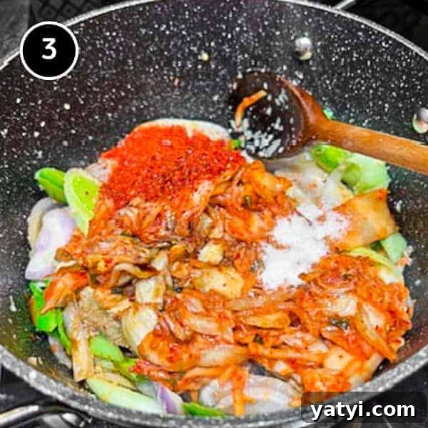 Kimchi Pork Stew | cookeatworld.com Adding kimchi and gochugaru chilli flakes to the Korean pork belly stew.