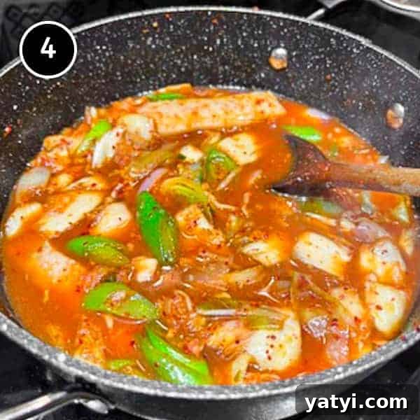 Kimchi Pork Stew | cookeatworld.com A pan of Korean kimchi pork stew simmering on a stove.