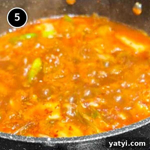 Kimchi Pork Stew | cookeatworld.com A pan of Korean kimchi pork stew simmering on a stove.