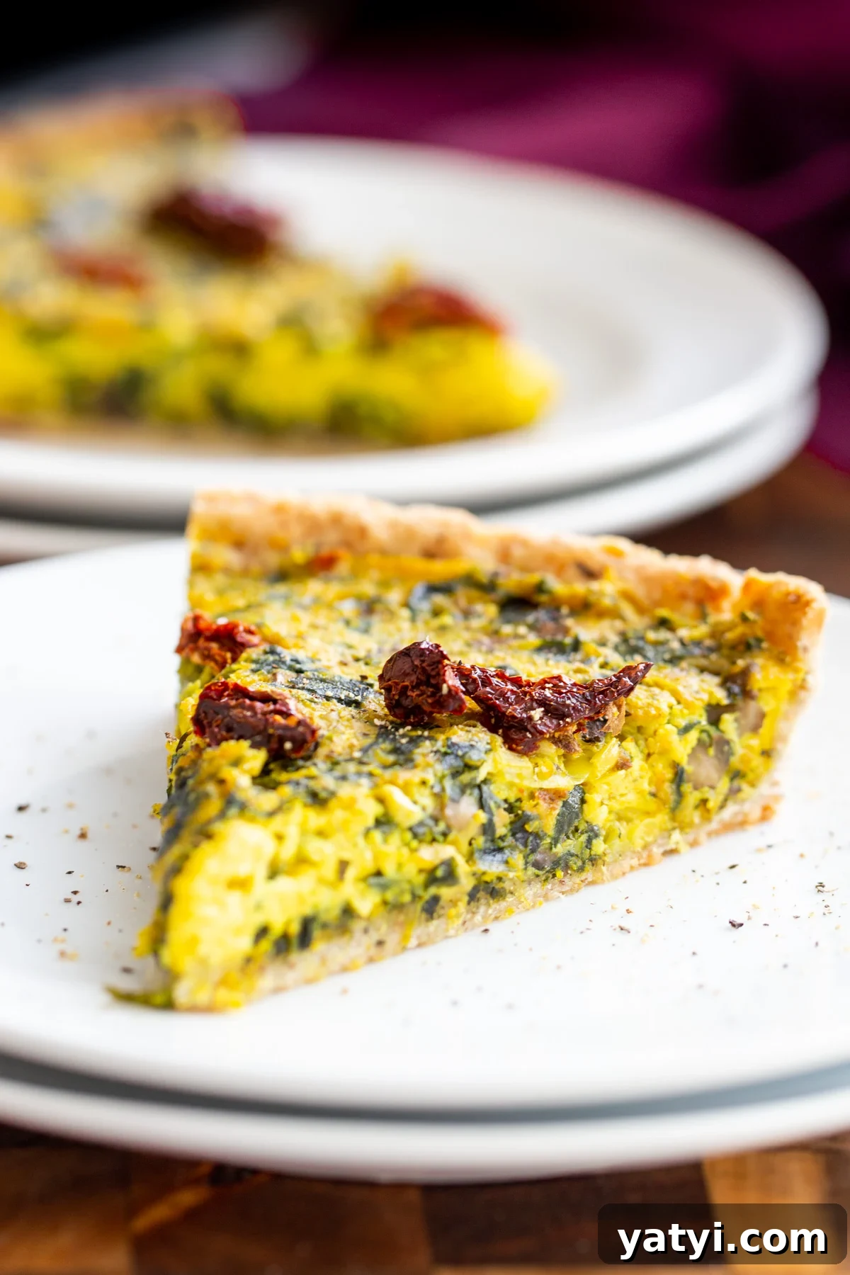 vegan quiche recipe a slice of vegan quiche on a white plate