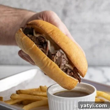 Crock Pot French Dip sandwich over a small bowl with au jus.