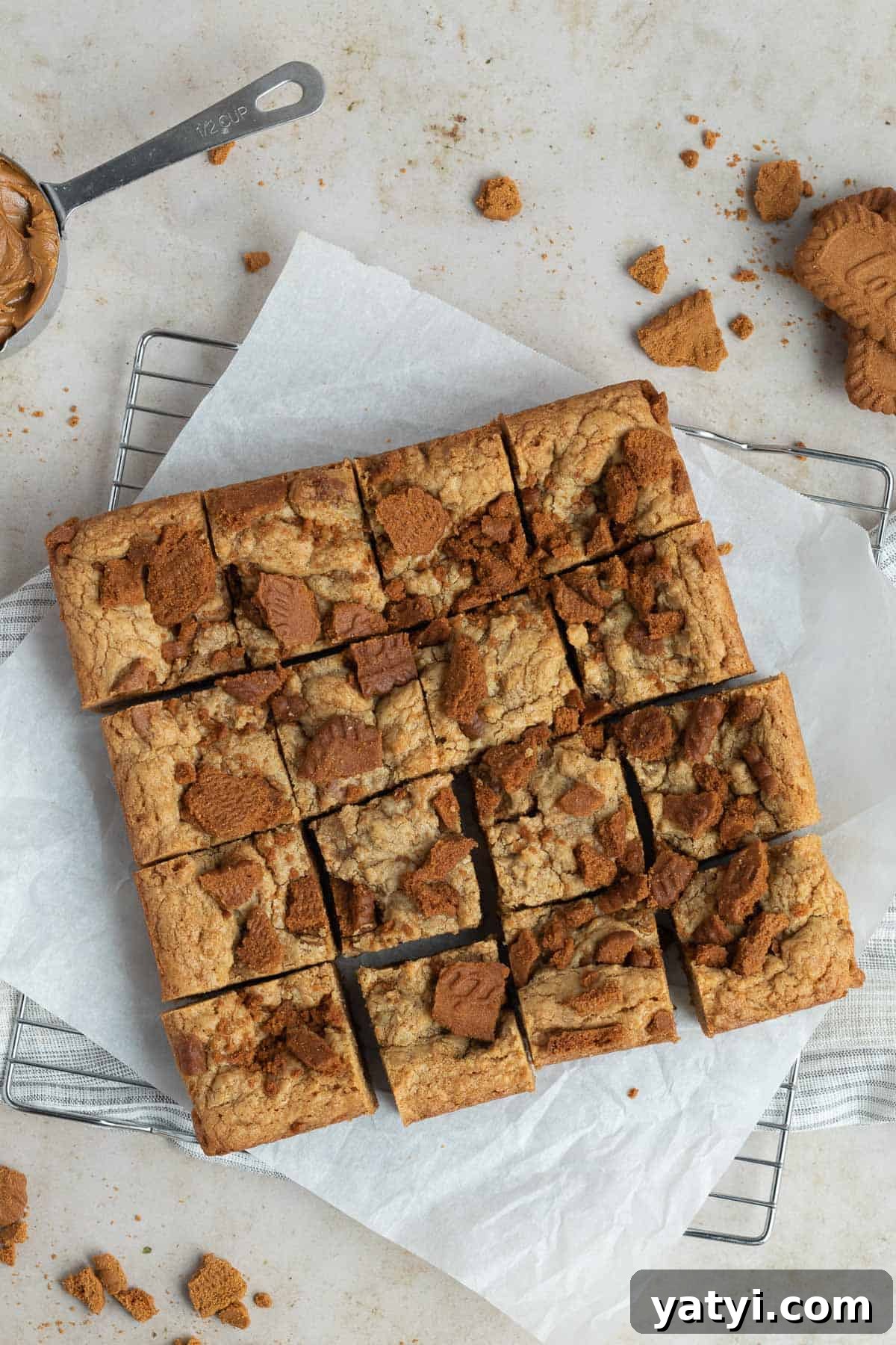 Chewy Biscoff Blondies with Caramelized Lotus Spread 2 a pan of sliced biscoff blondies on a piece of parchment paper