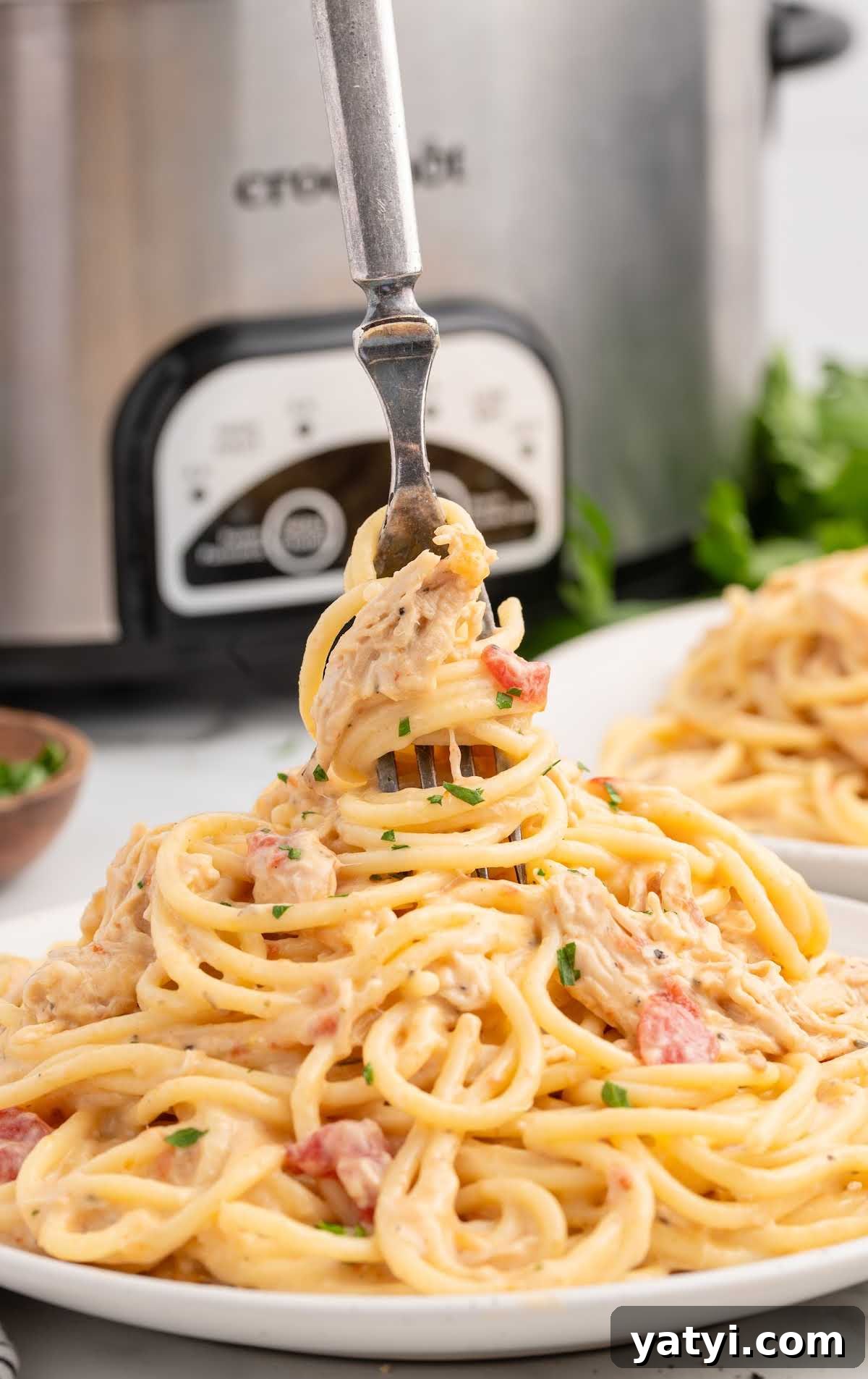Creamy Slow Cooker Chicken Spaghetti Recipe for Weeknight Meals 6 a plate of Chicken Spaghetti with a fork