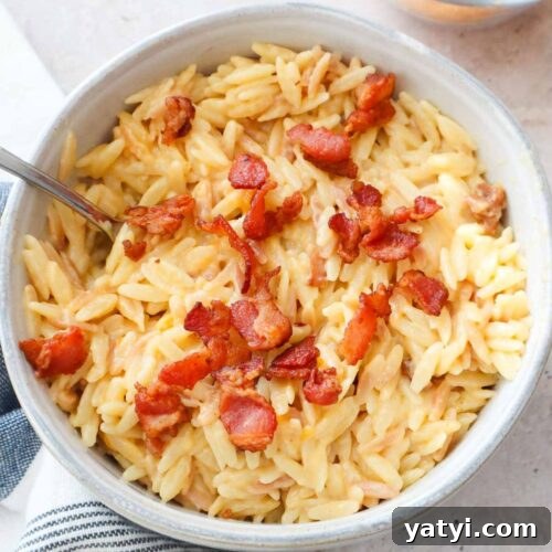 bowl with orzo mac and cheese topped with bacon.