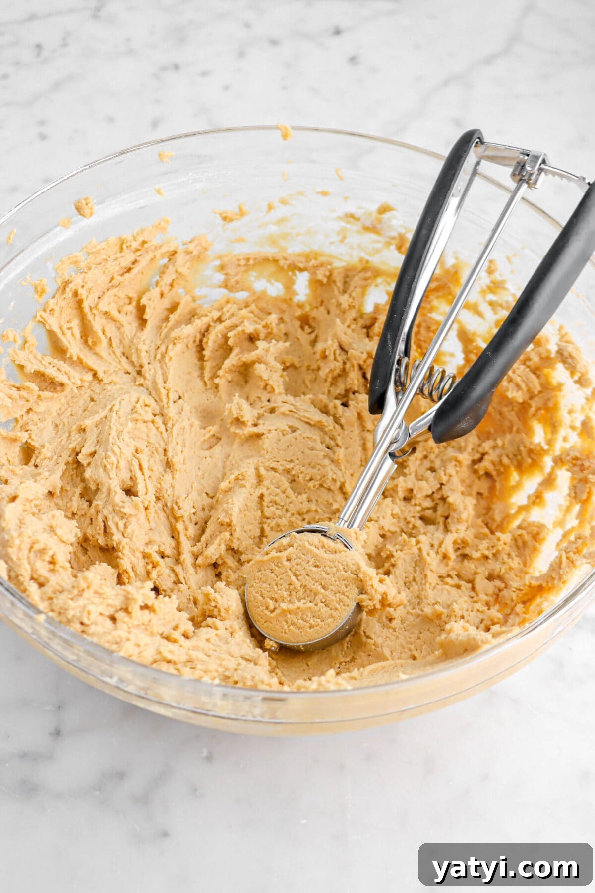 cookie scoop in bowl of cookie dough.