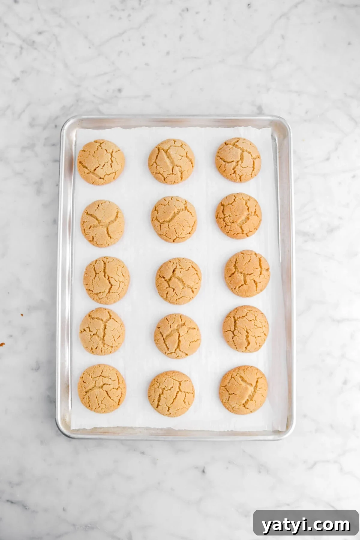 baked peanut butter cookies on lined sheet pan.