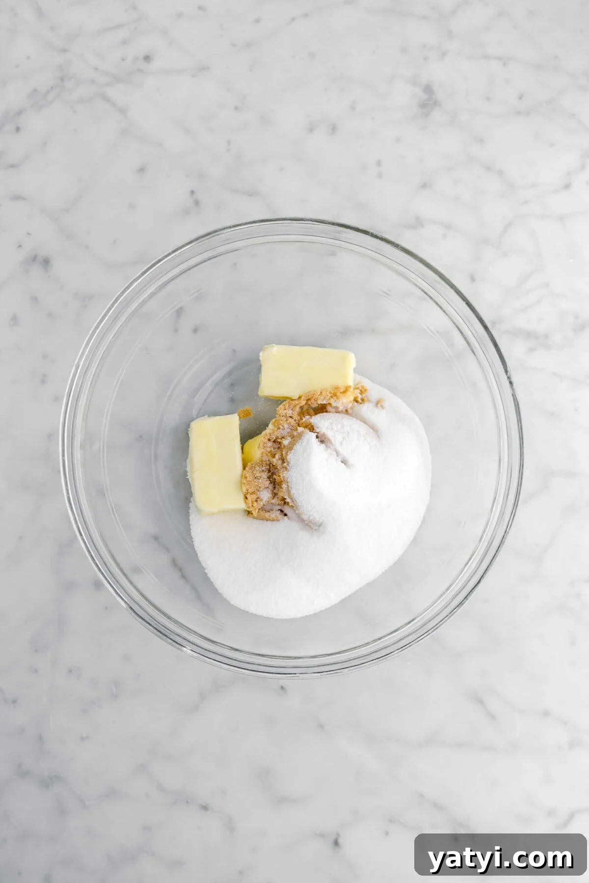 butter, granulated sugar, and brown sugar in glass bowl.