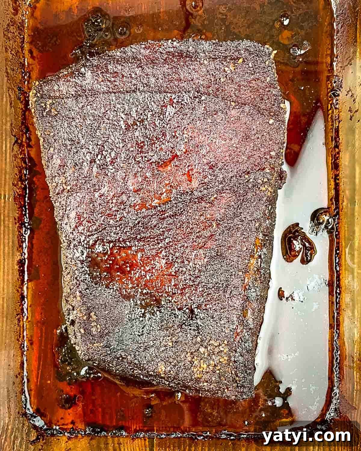 The oven finished brisket in the baking pan, showcasing a perfect crust.
