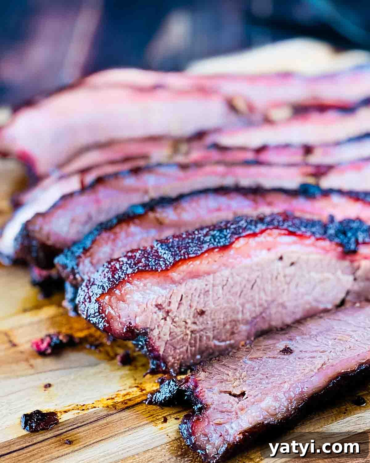 Slices of smoked brisket on a wooden cutting board.