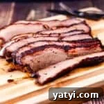 The juicy brisket cut into thin slices on a wooden cutting board.