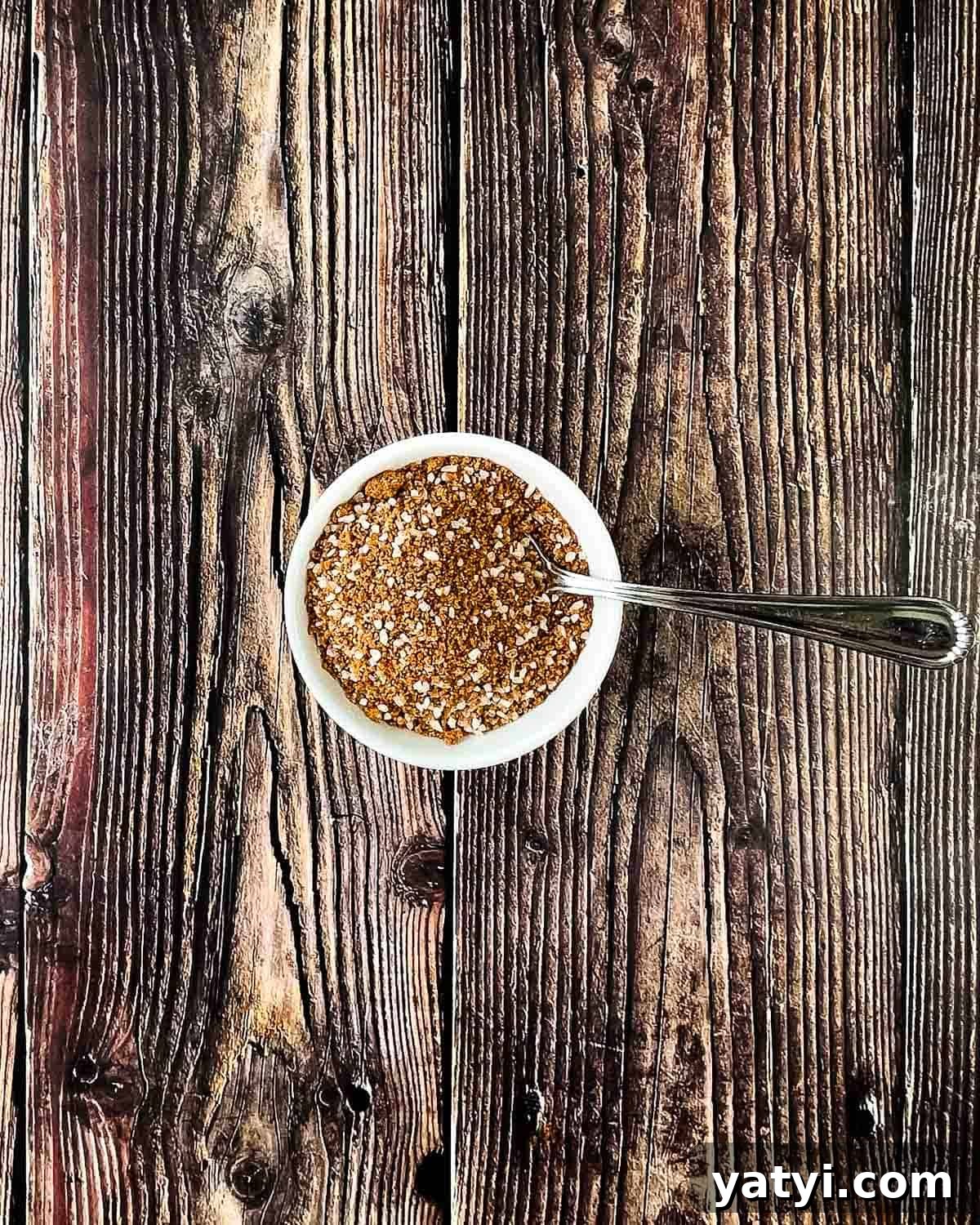 The ingredients for the dry rub mixed in a small white bowl with a spoon.