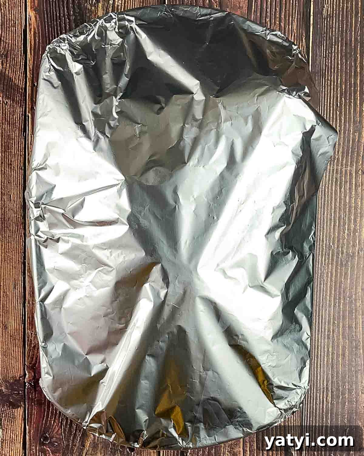 The brisket in a baking dish covered tightly with aluminum foil.