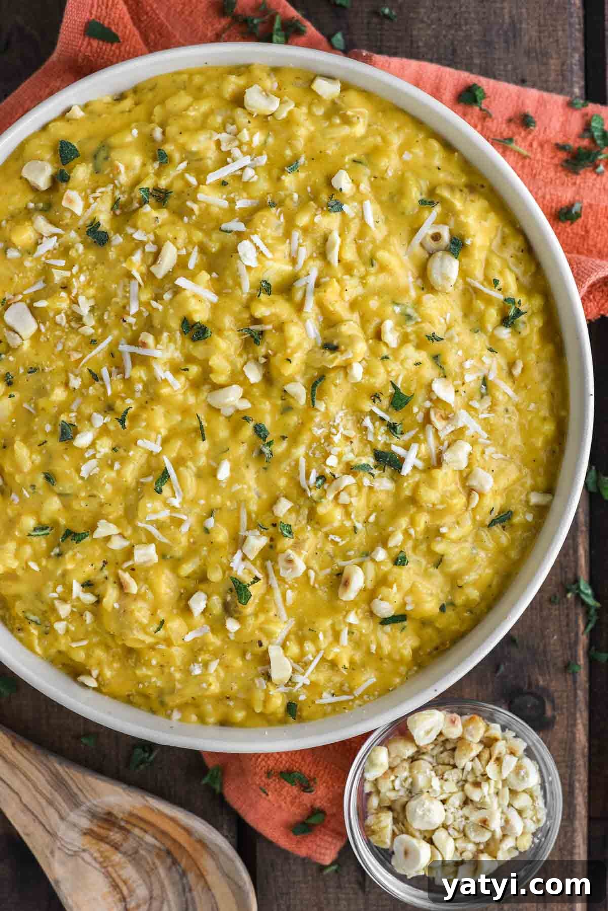 Creamy Chicken and Pumpkin Risotto Recipe for Fall Nights 2 Chicken and pumpkin risotto in bowl with small bowl of chopped hazelnuts.