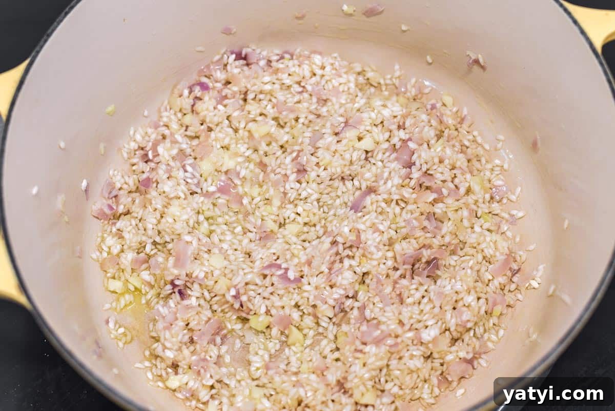 Creamy Chicken and Pumpkin Risotto Recipe for Fall Nights 5 Rice being quickly cooked in Dutch oven with shallots, garlic, butter and oil in Dutch oven.