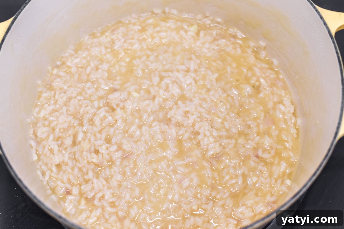 Creamy Chicken and Pumpkin Risotto Recipe for Fall Nights 7 Risotto being cooked in Dutch oven with the chicken stock.